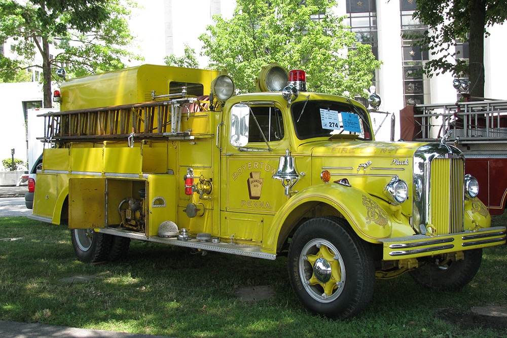 A yellow firetruck outside on grass
